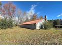 Gray stone building with red metal roof and partial view of yard at 133 Elmwood Rd, Statesville, NC 28625