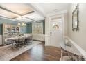 Bright dining room with a farmhouse table, hardwood floors, and a view of the entryway at 3030 Stephen Pace Trl, Huntersville, NC 28078