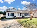 House exterior showcasing a gray siding, landscaping, and a paved driveway at 5136 Wheat Sw Dr, Concord, NC 28027