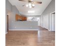 Open concept living room and kitchen with hardwood floors and neutral walls at 5136 Wheat Sw Dr, Concord, NC 28027