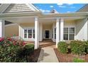 Covered front porch with white columns, stone flooring, and pink flowers at 4022 Blackburn Ct, Fort Mill, SC 29707