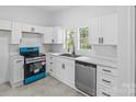 Renovated kitchen, white cabinets, blue stove, and modern appliances at 612 E E St, Newton, NC 28658