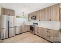 Modern kitchen with light wood cabinets, stainless steel appliances, and white countertops at 4919 Country Oaks Dr, Rock Hill, SC 29732