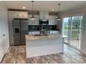 Modern kitchen with island, stainless steel appliances, and gray tile backsplash at 51 Rosemont Dr, Stony Point, NC 28678