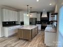 Modern kitchen with white cabinets, marble countertops, and an island at 568 Drumstand Rd, Stony Point, NC 28678