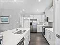 Modern kitchen with white cabinets, stainless steel appliances, and a herringbone backsplash at 7315 Childress Sw Dr, Concord, NC 28025