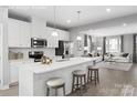Open concept kitchen with island, white cabinets, and stainless steel appliances at 7329 Braswell Sw Dr, Concord, NC 28025