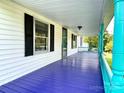 Inviting front porch with purple and teal painted floors at 142 Swink Sw St, Concord, NC 28027