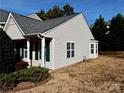 Tan home with green shutters and a side yard, showcasing exterior details at 7374 Sun Dance Dr, Fort Mill, SC 29707