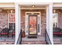 Brick front porch with two wicker chairs and a glass front door at 157 Montibello Dr, Mooresville, NC 28117