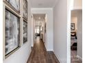 Bright hallway with hardwood floors and artwork leading to other rooms at 1277 Morehead Dr, Salisbury, NC 28144