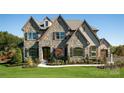 Two-story house with stone accents and a two-car garage at Lot 47 Watercourse Way # Devonshire, Belmont, NC 28012