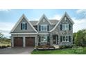 Two-story house with gray siding, stone accents, and a two-car garage at Lot 42 Watercourse Way # Hawthorne, Belmont, NC 28012