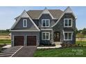 Two-story home with gray shingle siding, stone accents, and a two-car garage at Lot 42 Watercourse Way # Hawthorne, Belmont, NC 28012