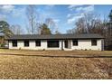 Ranch style home with white brick exterior, dark windows, and a gray roof at 3700 Pinecrest Dr, Gastonia, NC 28056
