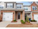 Townhome entrance with brick exterior, double garage, and well-maintained landscaping at 3950 Rothwood Ln, Harrisburg, NC 28075