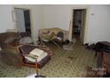 Living room with cluttered furniture and worn carpet at 523 Hoyle St, Dallas, NC 28034