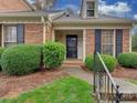 Front entrance of brick townhouse with landscaping at 9128 Nolley Ct # G, Charlotte, NC 28270