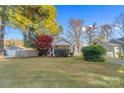 Single-story home with fenced yard, mature trees, and autumn colors at 128 Hugh Caldwell Rd, Charlotte, NC 28214