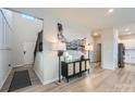 Bright entryway with hardwood floors, black console table, and view to kitchen at 3582 Cerelia Ln, Denver, NC 28037