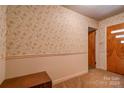 Entryway with floral wallpaper, wood-paneled door, and storage bench at 608 Hanover Dr, Shelby, NC 28150