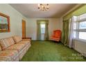 Living room with green carpeting, orange chair, and floral sofa at 608 Hanover Dr, Shelby, NC 28150
