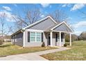 Gray house with white trim and black shutters, covered porch, and a landscaped yard at 710 W Alabama Ave, Bessemer City, NC 28016