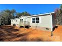 Tan mobile home exterior with wooden deck and surrounding trees at 3357 34Th Avenue Ne Ct, Hickory, NC 28601