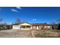 Brick ranch home features a covered carport and mature trees at 7855 Nc Highway 90 E None, Stony Point, NC 28678