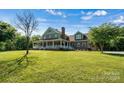 Brick house with a wrap-around porch, showcasing a beautiful front yard at 1727 Will Schronce Rd, Lincolnton, NC 28092