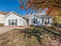 Gray siding ranch home with mature trees and landscaping at 3916 Cedarbark Dr, Matthews, NC 28105