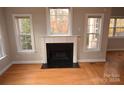 Fireplace with white mantel and granite hearth in a sunlit room at 809 Pine Forest Rd, Charlotte, NC 28214