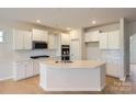 Modern kitchen with white cabinets, quartz countertops, and island at 223 Hamptons Cove Rd, Troutman, NC 28166