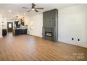 Open living room with hardwood floors, a gas fireplace, and a view of the kitchen at 255 Bellhaven Nw Pl, Concord, NC 28027