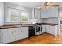 Galley kitchen with white cabinets, hardwood floors, and modern appliances at 1340 Chester Hwy, York, SC 29745