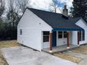 White house with blue trim, a dark roof, and a concrete driveway at 123 Oak St, Chester, SC 29706