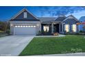 Two-story home with gray siding, brick accents, and a three-car garage at night at 13722 Berkley Ave, Huntersville, NC 28078