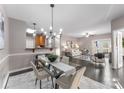 Open concept dining area features a glass table and modern chandelier at 9145 Mcdowell Creek Ct, Cornelius, NC 28031