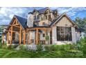 Back exterior showcasing screened porch and stone fireplace at 0 S Potter Rd # 2B, Waxhaw, NC 28173