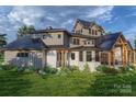 Home's back exterior boasts a large covered patio and stone fireplace at 0 S Potter Rd # 2B, Waxhaw, NC 28173