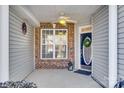 Inviting front porch with brick and siding detail, ceiling fan, and entry door at 312 Garnet Ct, Fort Mill, SC 29708