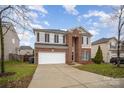 Two-story brick home with a white garage door and driveway at 10319 Dominion Village Dr, Charlotte, NC 28269