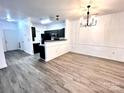 Bright dining area with an open floor plan, dark kitchen cabinets, and wood-look flooring at 11238 Hyde Pointe Ct, Charlotte, NC 28262