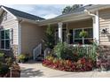 Front porch with white railings, red flowers, and stone accents at 14425 Beatties Ford Rd, Huntersville, NC 28078