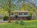 Ranch style home with a brick and gray exterior and manicured lawn at 4512 Gainesborough Rd, Charlotte, NC 28205