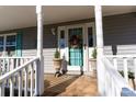 Inviting front porch with teal door and white columns at 702 Pierce Ave, Mount Holly, NC 28120