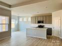 Modern kitchen with gray cabinets, white subway tile backsplash, and an island at 1066 Bull Dog Ln, Wingate, NC 28174