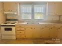 Small kitchen with light cabinets, electric stove, and double sink at 707 7Th St, Spencer, NC 28159