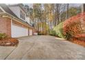 White 3-car garage with brick exterior and landscaped side yard at 12539 Overlook Mountain Dr, Charlotte, NC 28216