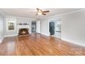 Living room with hardwood floors, fireplace, and view of kitchen at 407 King St, Monroe, NC 28110